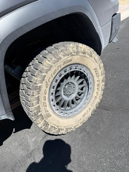 Close-up of a GMC Sierra off-road wheel and mud tire after degreasing
