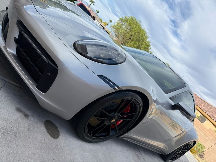 Silver Porsche 911 Turbo S front end reflecting the sky after a gloss detail