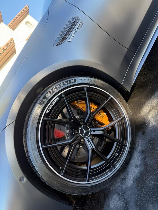 Close-up of an AMG forged wheel and yellow brake caliper after a deep clean