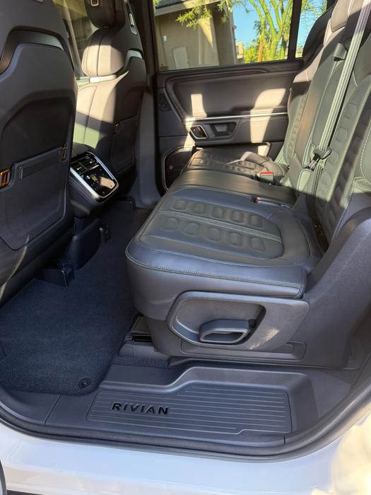 Rivian R1S rear seating area with deep-cleaned floor mats and console