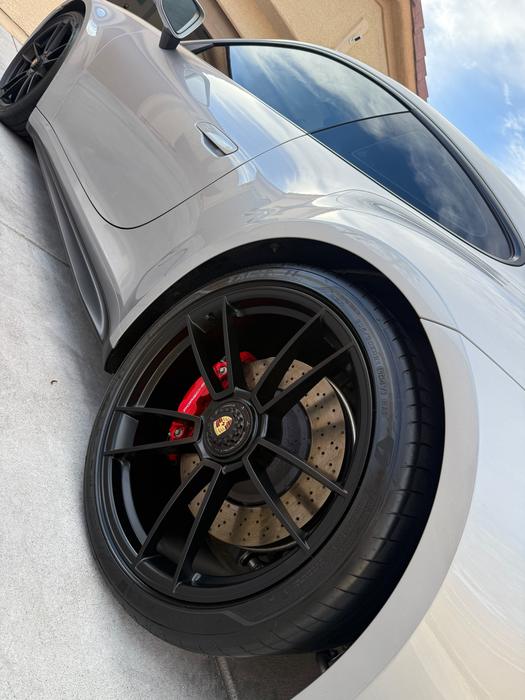 Porsche 911 Turbo S wheel, red caliper and carbon-ceramic rotor after a deep clean