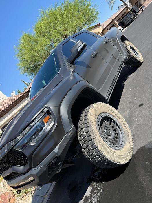 Lifted grey GMC Sierra front three-quarter view after detailing
