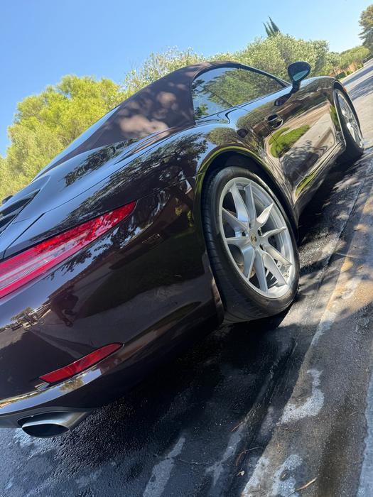 Porsche 911 Cabriolet side profile showing corrected paint reflecting the treeline