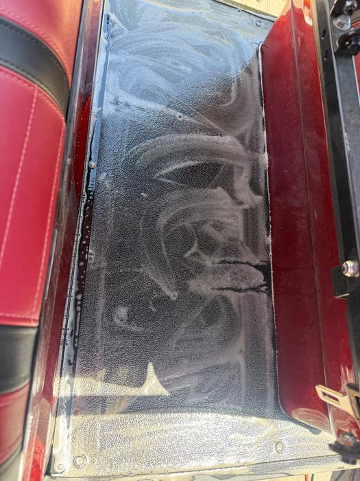 Candy red custom golf cart windshield covered in wash foam during a detail