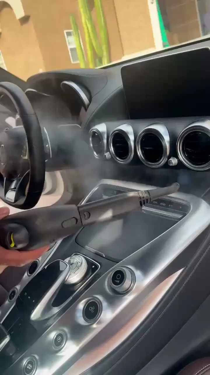 Steam wand cleaning the vents and console of a Mercedes-AMG GT interior